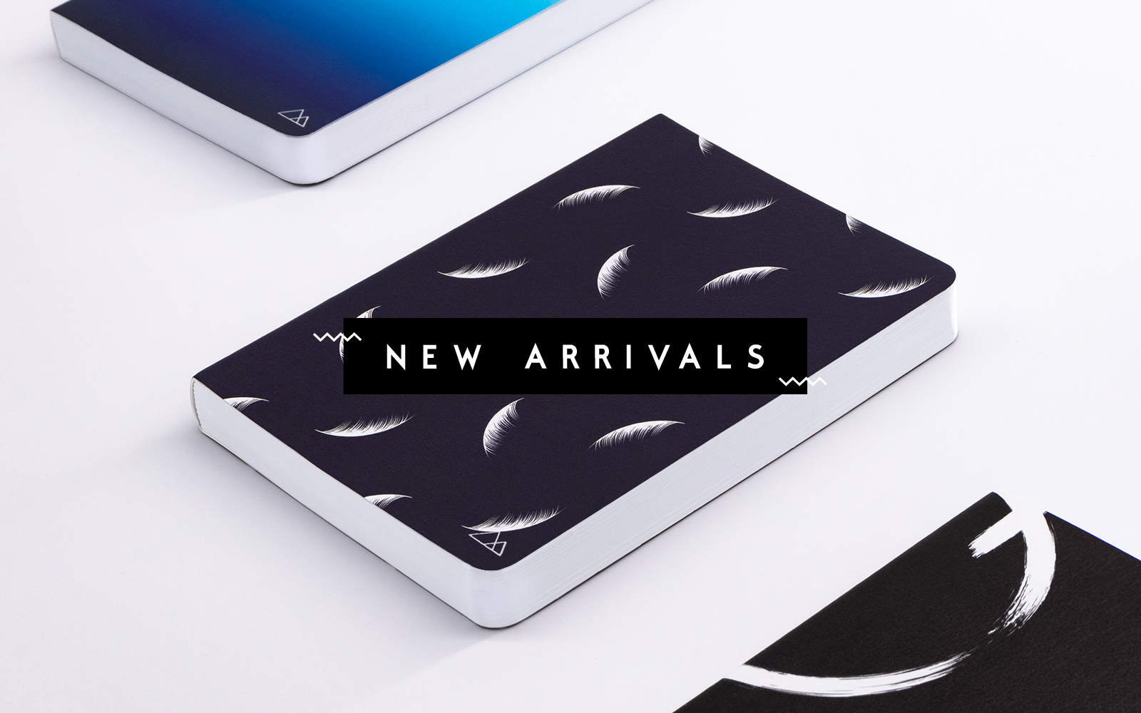 Three notebooks on a table to represent new notebook arrivals